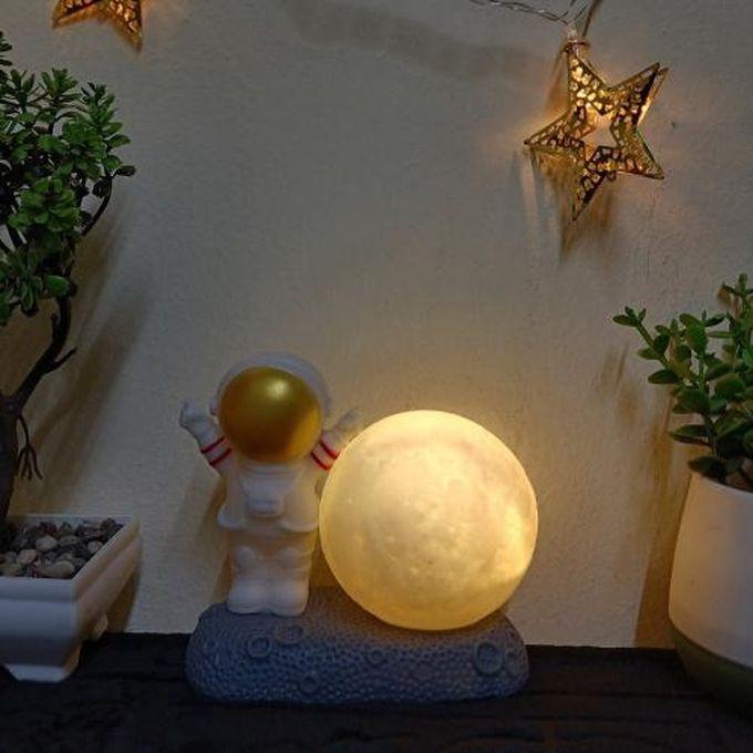 A Spaceman Lamp Next To A Decorative Moon Bed Side Light