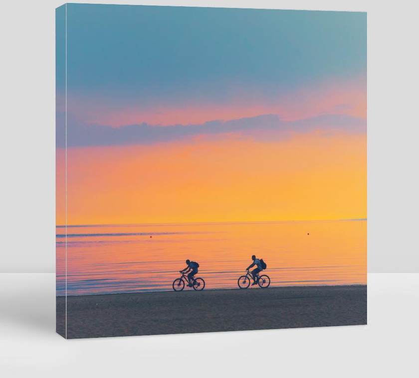 Biker Silhouette Riding Along Beach at Sunset