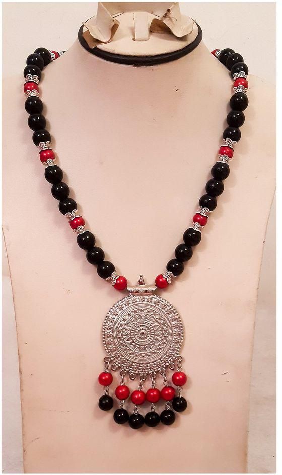 A Beautiful Necklace Of Black And Red Beads With Silver Pendant